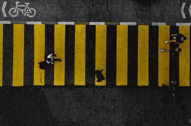 overhead view of people walking across a crosswalk